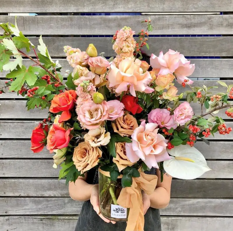 A woman holds a huge, beautiful bouquet of flowers from Melbourne flower delivery company Lillypad - flowers are one of the best Melbourne gifts to deliver!